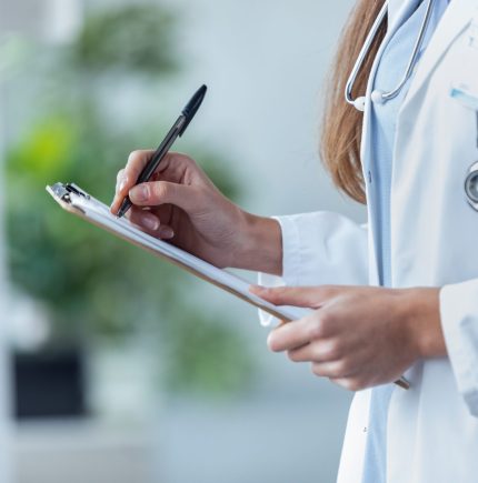 Close-up,Of,A,Female,Doctor,Filling,Up,Medical,Form,At